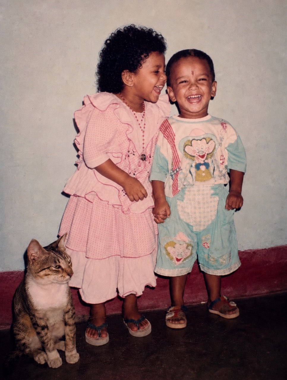 Generated vintage-style photo of both children laughing with the cat nearby