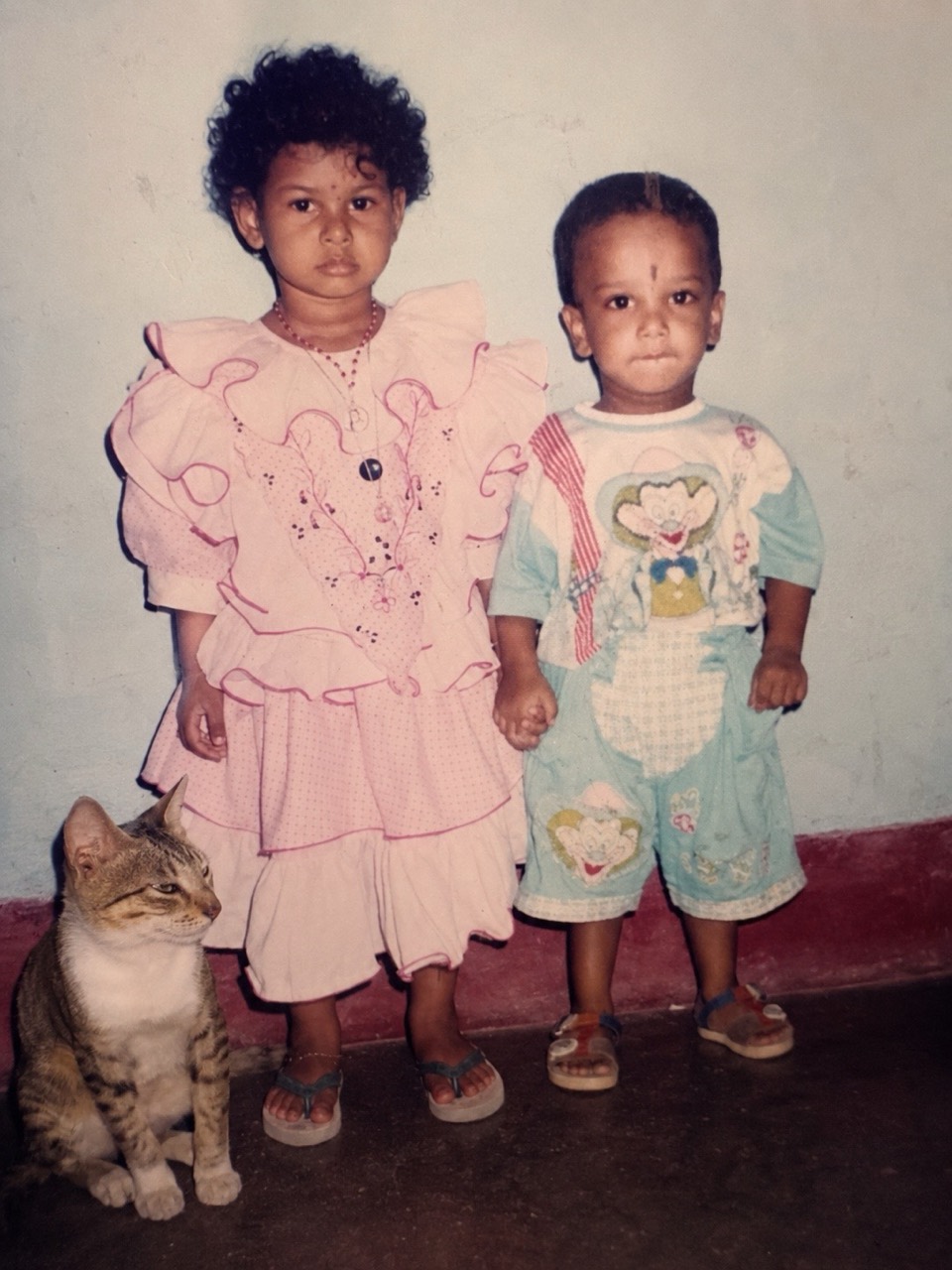 Generated vintage-style photo of two children holding hands with a cat nearby