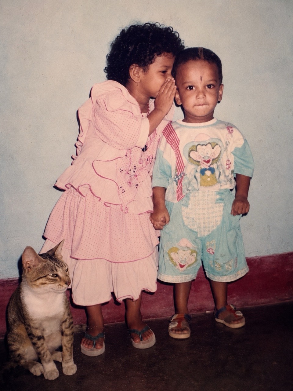 Generated vintage-style photo of the girl whispering to the boy with the cat nearby